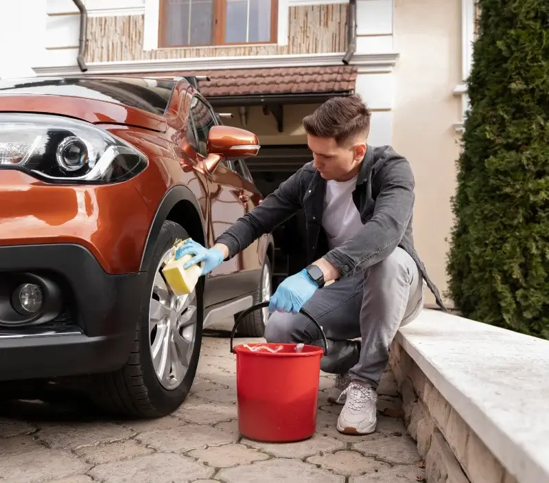 Lavage auto à domicile Vrécourt : professionnel intervenant sur un véhicule